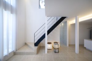 さいたま市のホテルライクな注文住宅。吹抜けの開放感を損ねないブラックのアイアン手摺がおしゃれなスケルトン階段。