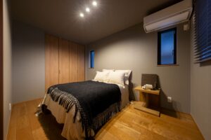 さいたま市のホテルライクな注文住宅。ウォルナットの床とグレーの壁が落ち着きをもたらす癒しの寝室。